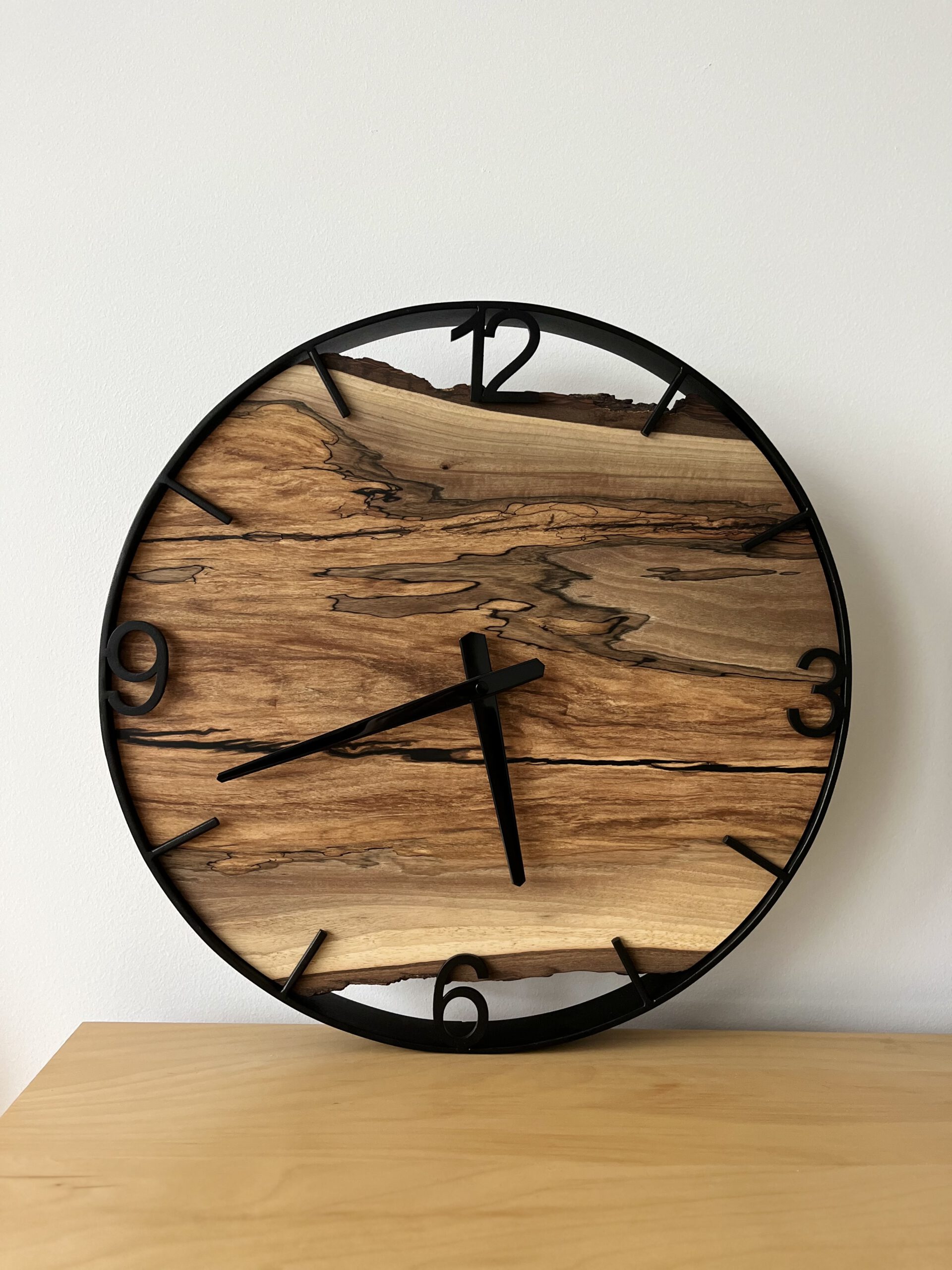 Wzorzysty zegar z drewna orzecha w stalowej obręczy